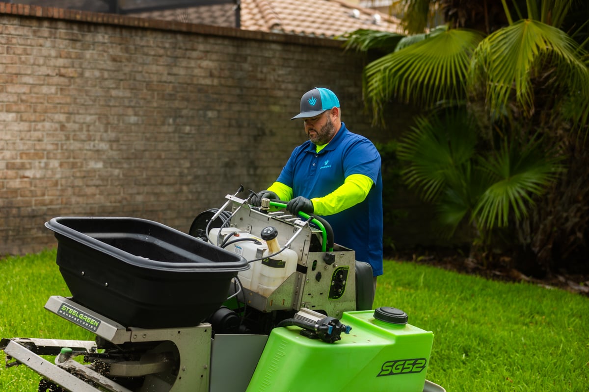 lawn care technician fertilizing grass in Tampa Bay