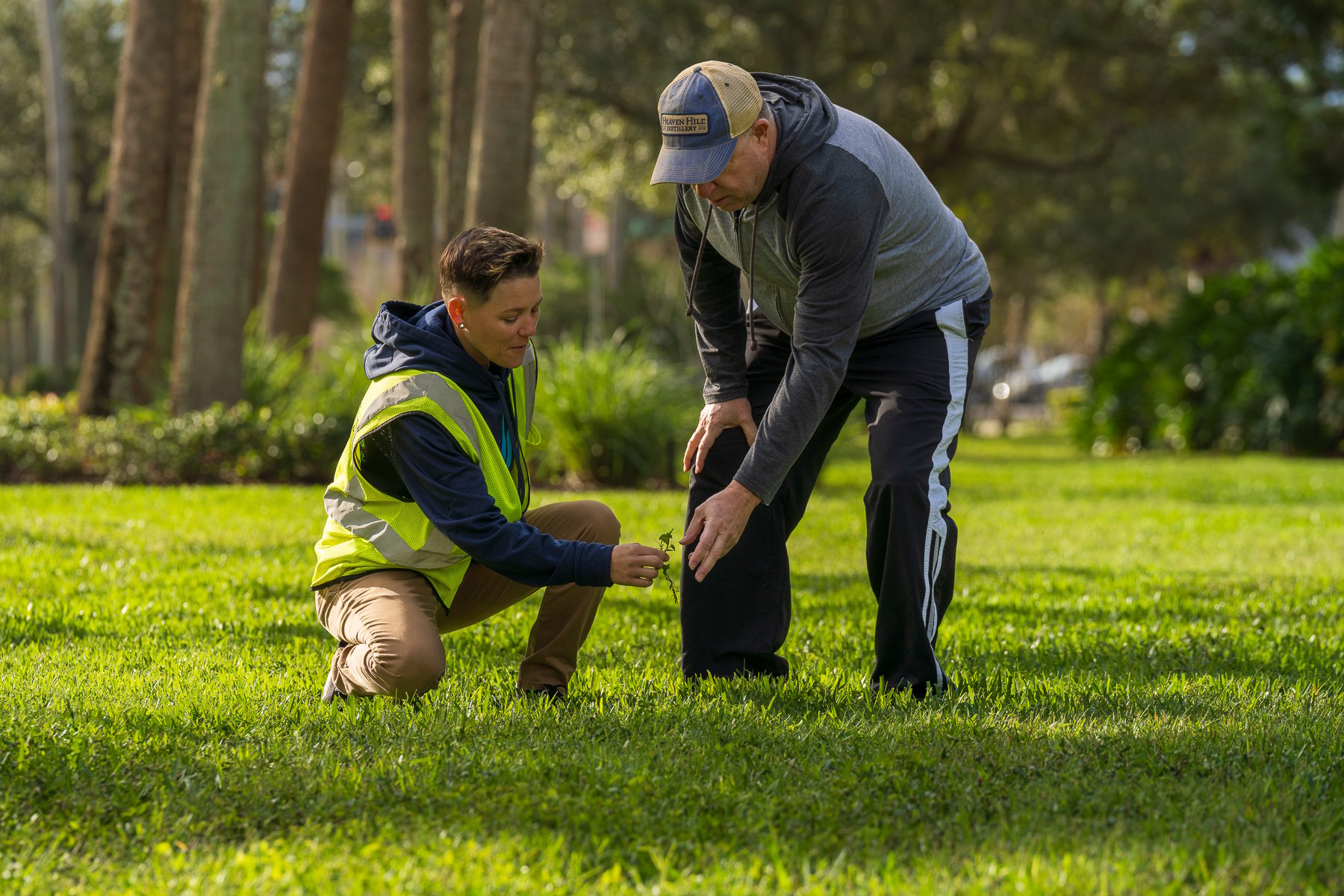 Account manager walking with HOA board member around property inspecting weeds