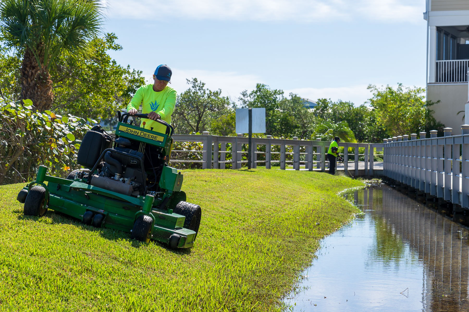 Landscape maintenance crew mowing along water