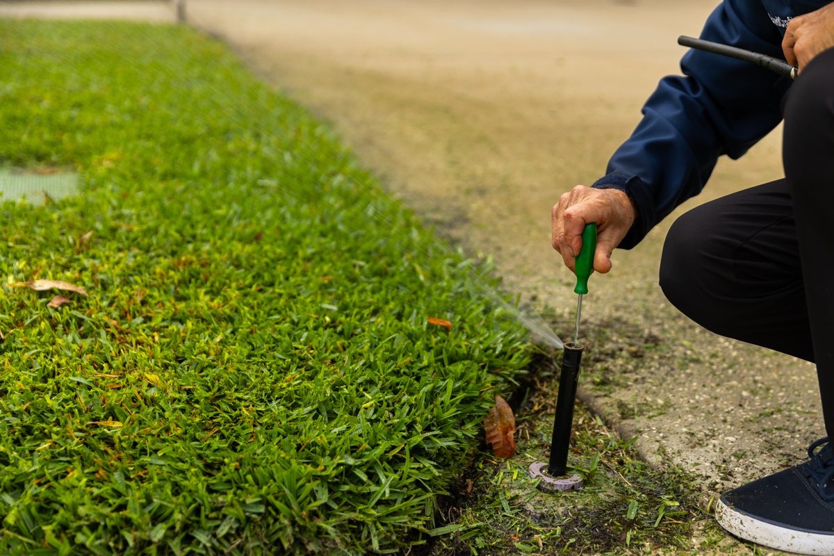 irrigation tech repairing sprinkler