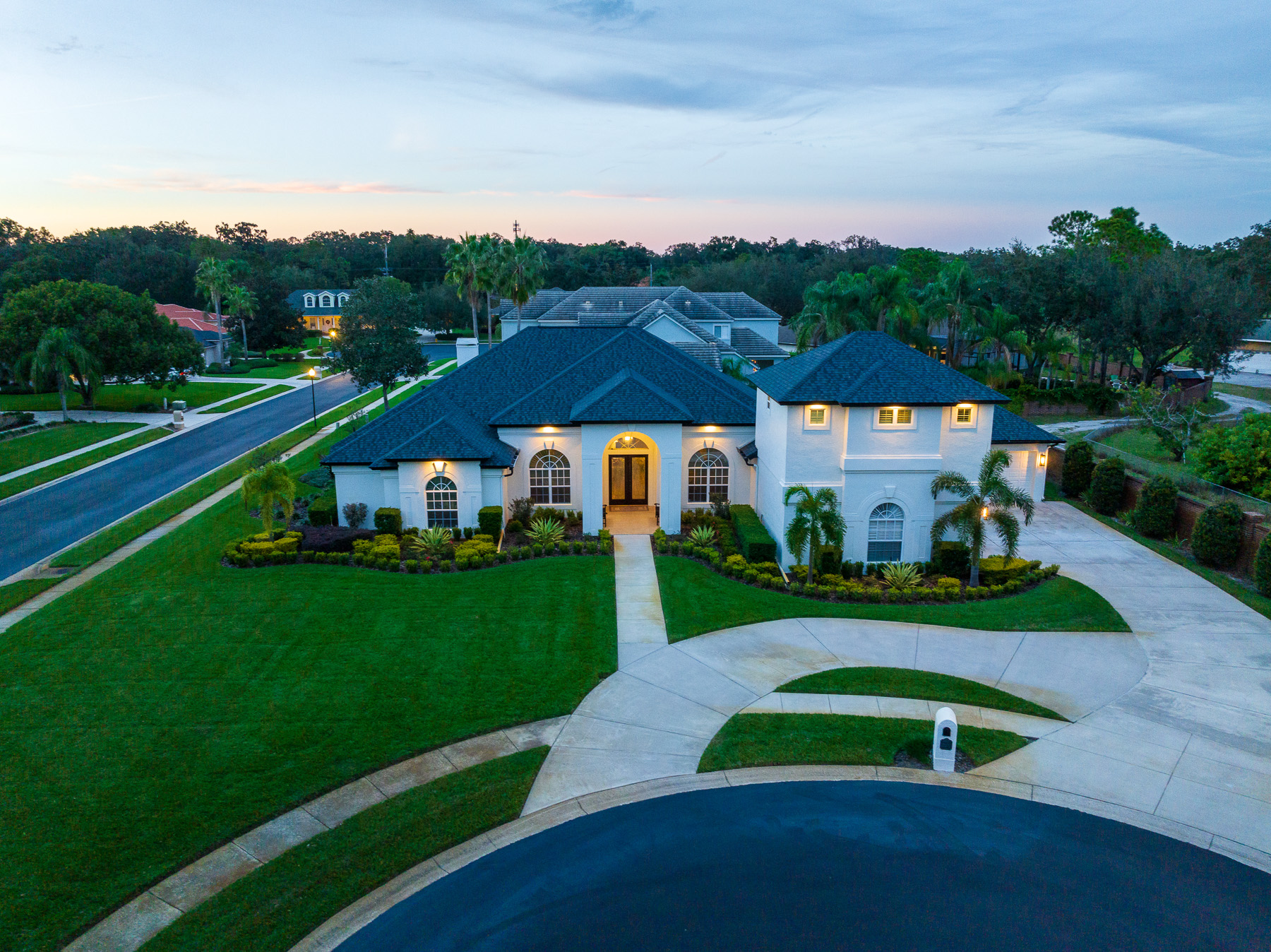 Front of house with green grass and landscape beds 