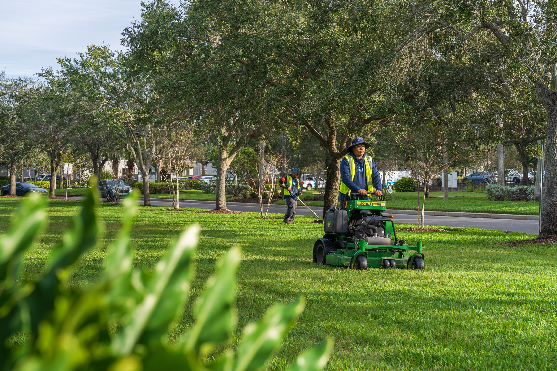 landscape crew mowing and edging large green grass area