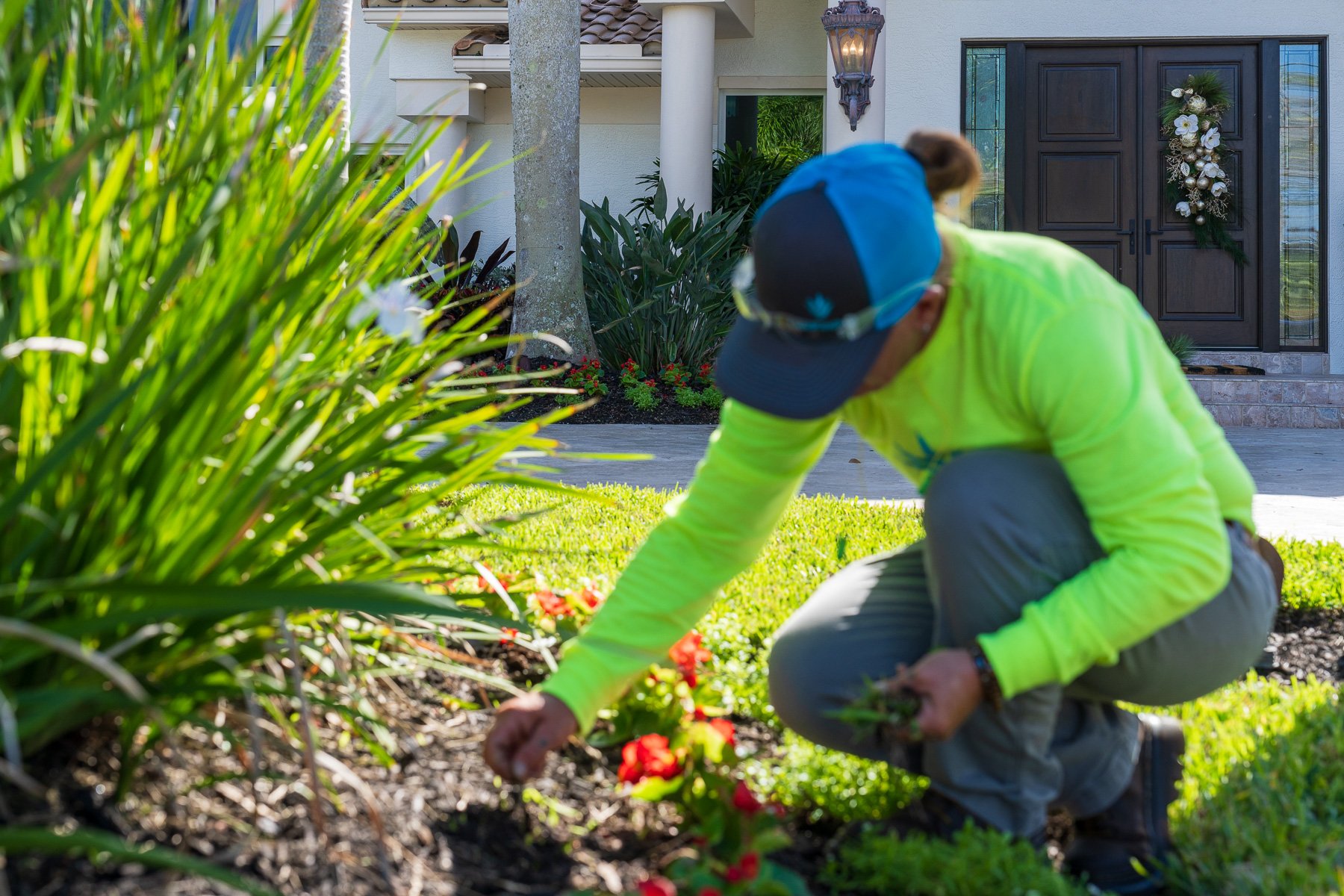 residential landscape maintenance crew member cleaning up garden bed 2
